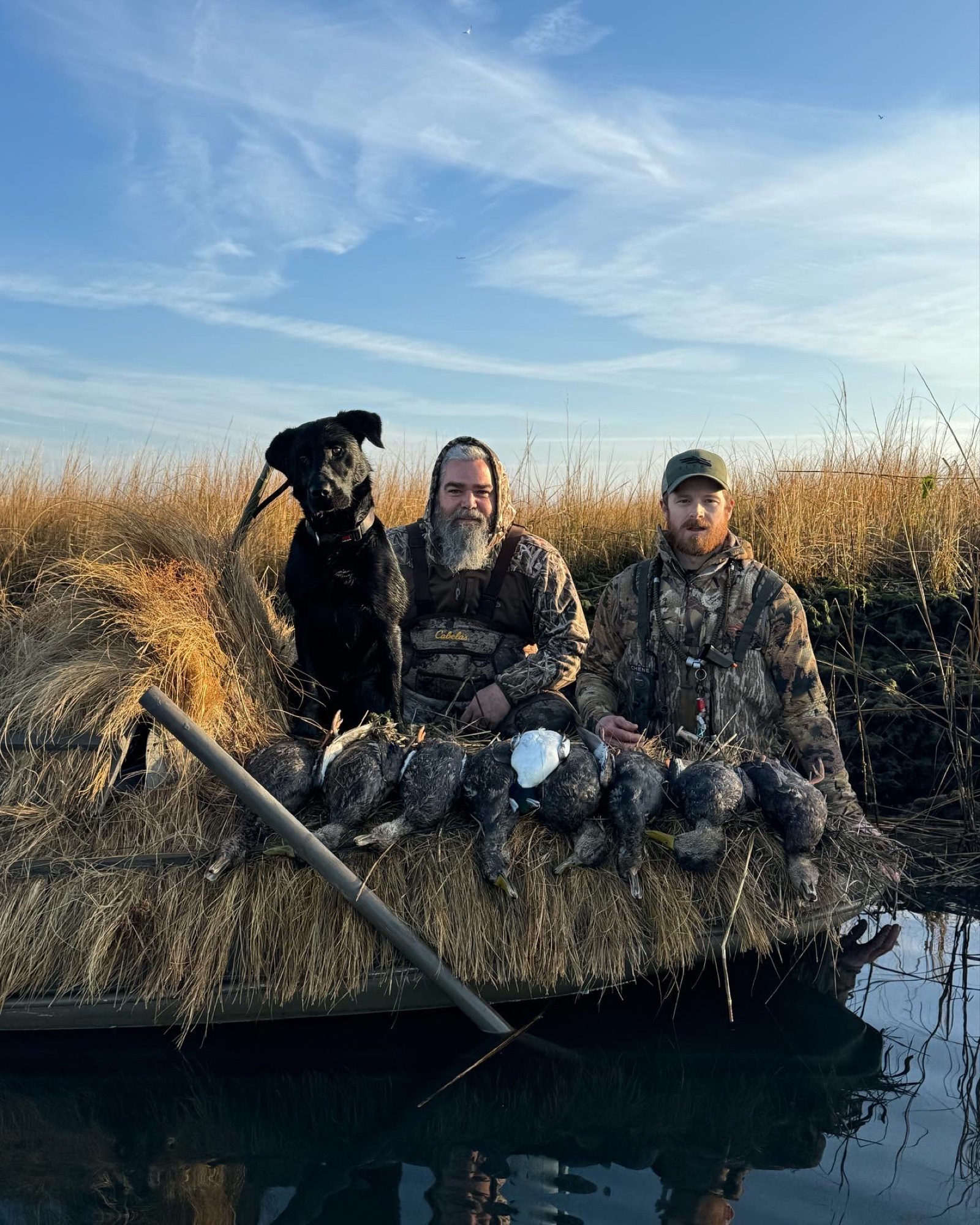 Hunters with duck limit in grass boat on Long Island south shore
